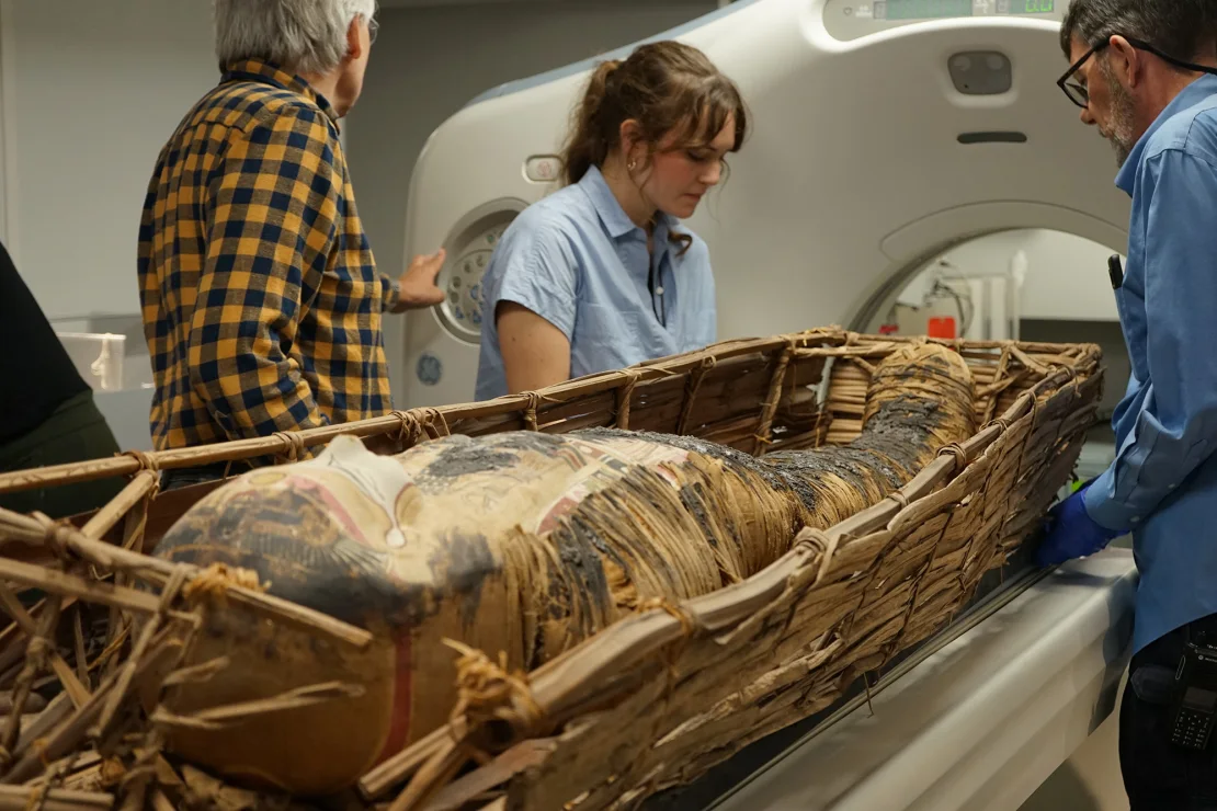 Researchers at the Field Museum scan a mummified individual displayed in the "Inside Ancient Egypt" exhibition.